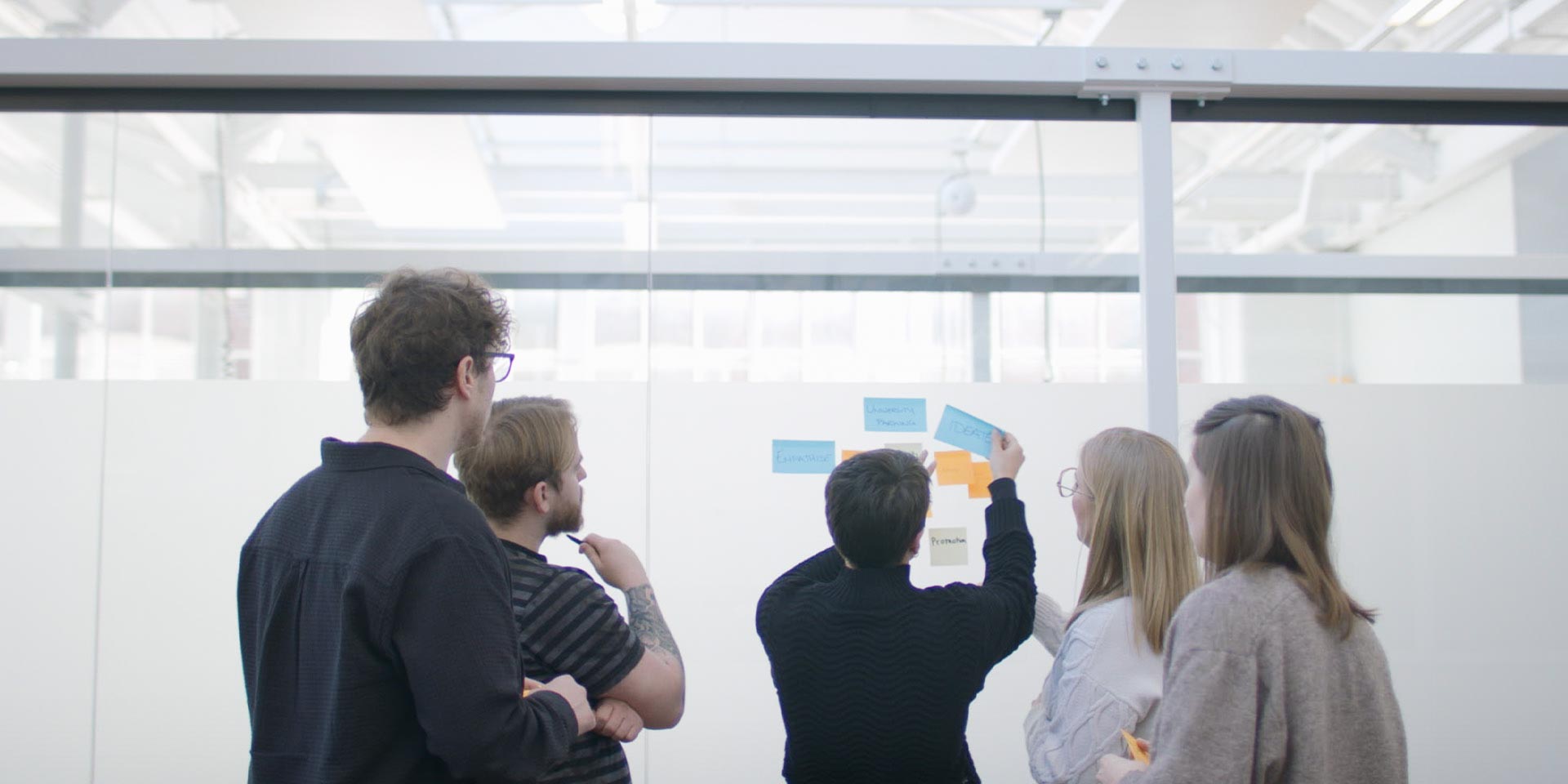 A collaborative workshop setting with team members collaborating around sticky notes and whiteboards to design innovative solutions.